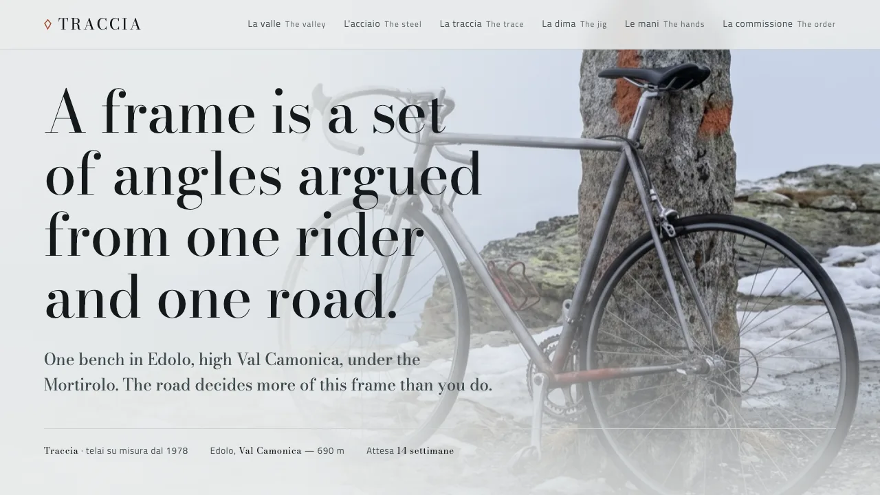 Traccia homepage showing a steel frame leaning against a painted stone marker in alpine snow-light.